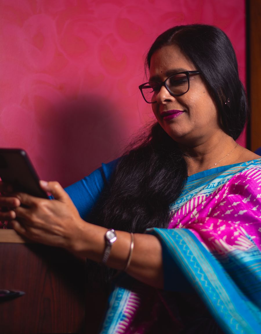 An Indian customer reading a message on her phone at home