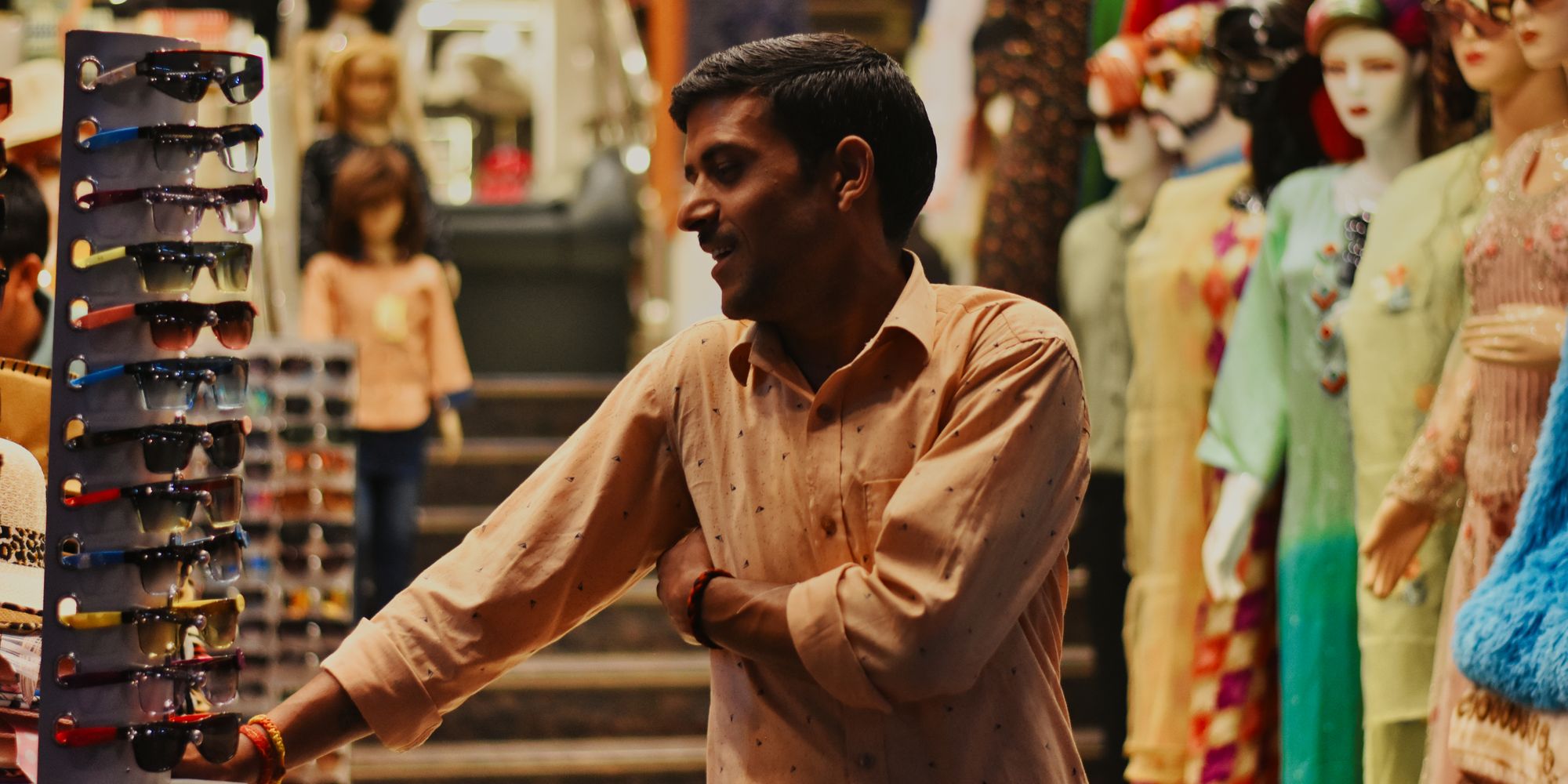An Indian shopkeeper smiling with a happy customer at the counter