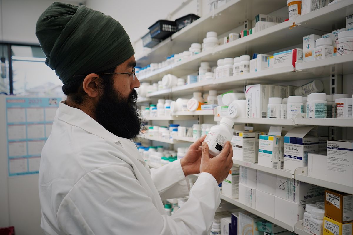 A pharmacist arranging medicines in an Indian medical store