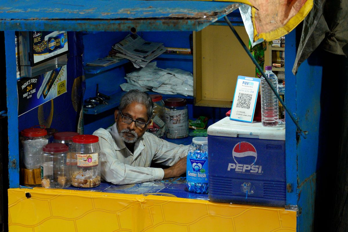 A kirana store owner behind the counter of his shop